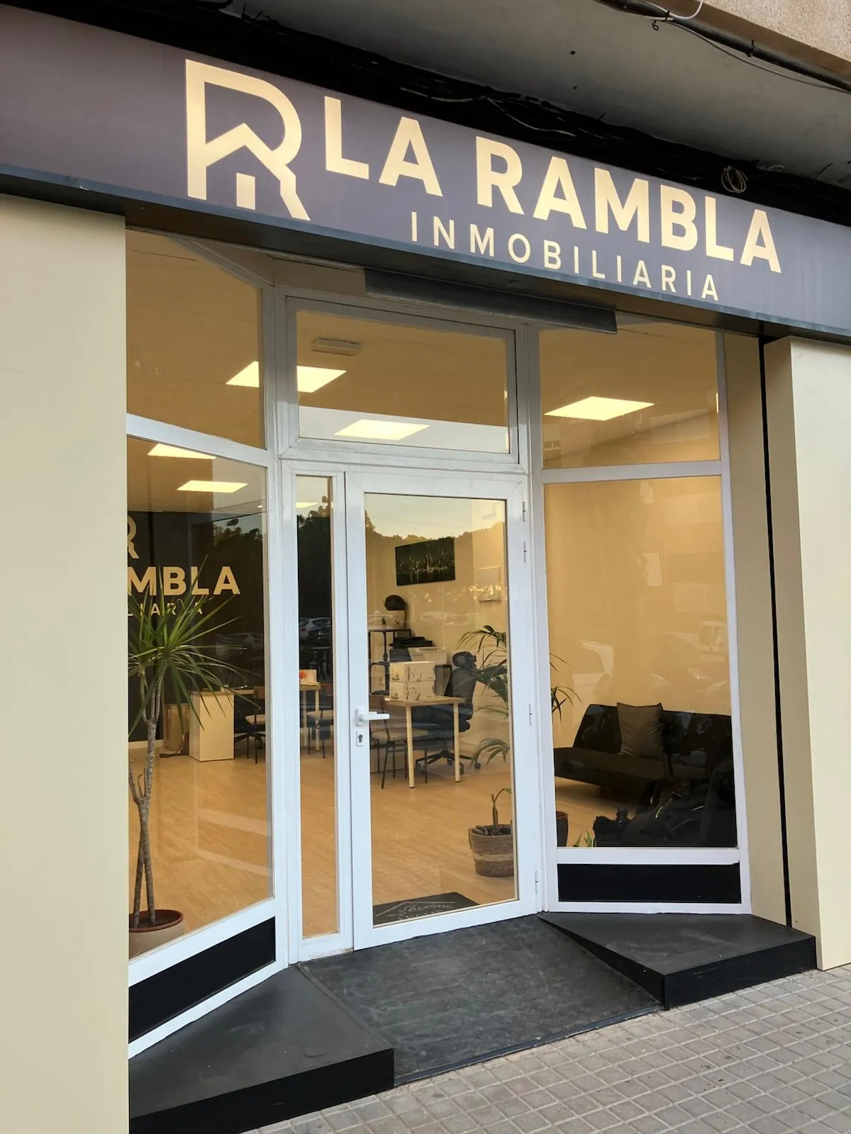 Fachada de una inmobiliaria de Catarroja con la puerta de entrada y el ventanal contiguo donde se instalaron las carpetas LED